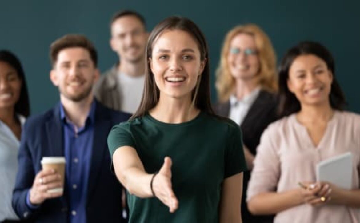 ragazza tende la mano con persone sullo sfondo